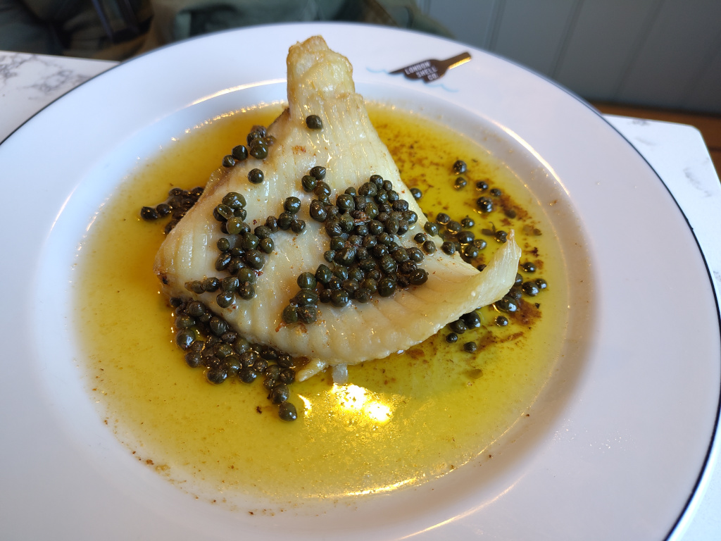 A ray wing covered in butters with capers in it.